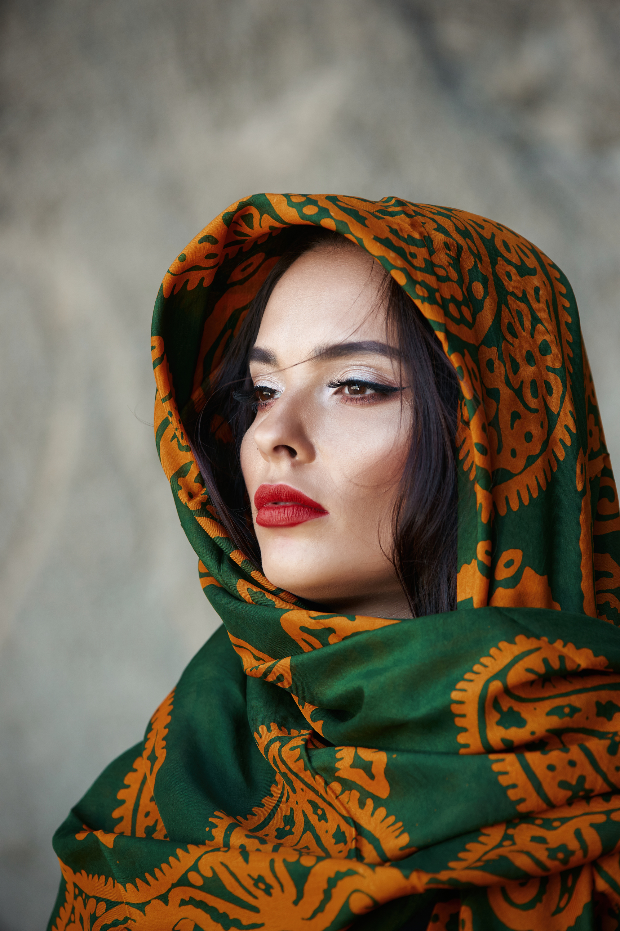 The woman's portrait in a oriental scarf. Mountain background.